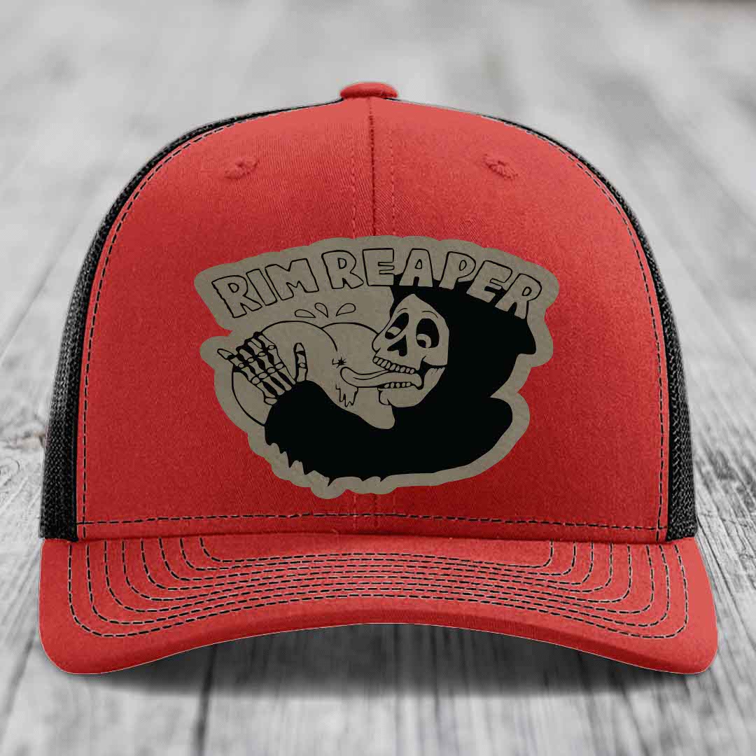 Red trucker hat with black mesh back and gray skull graphic that says Rim Reaper