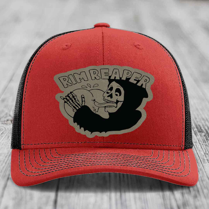 Red trucker hat with black mesh back and gray skull graphic that says Rim Reaper