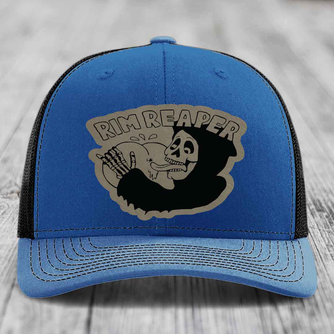 Blue trucker hat with black mesh back and gray skull patch that says &