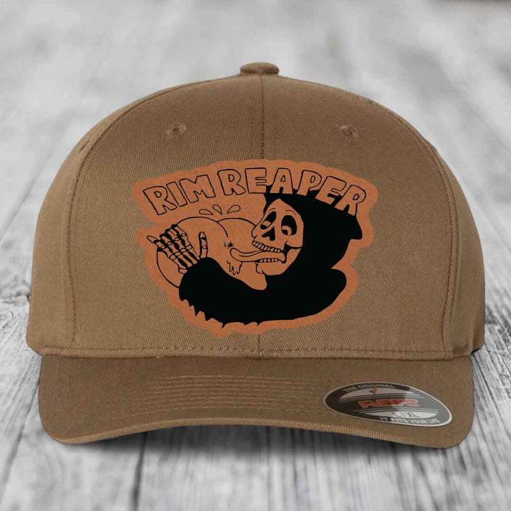 Tan baseball cap with orange Rim Reaper skull patch and Flexfit label.