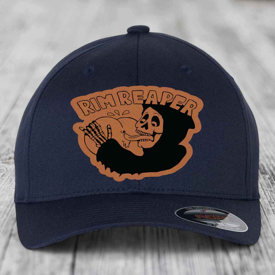 Dark blue baseball cap with a brown leatherette patch featuring a skeleton holding a basketball and the text &