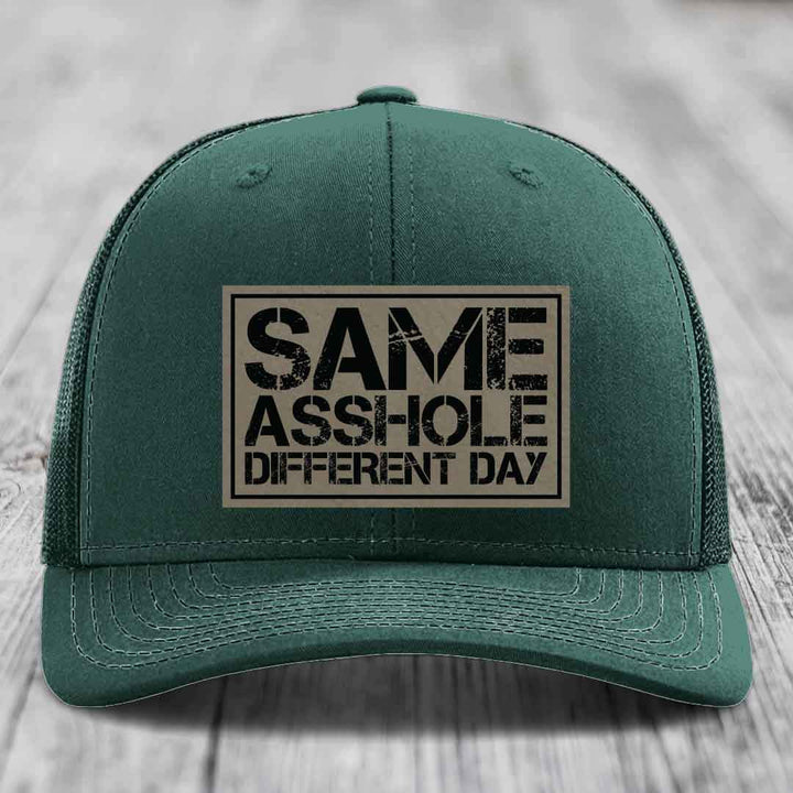 Green trucker hat with a rectangular patch that reads &