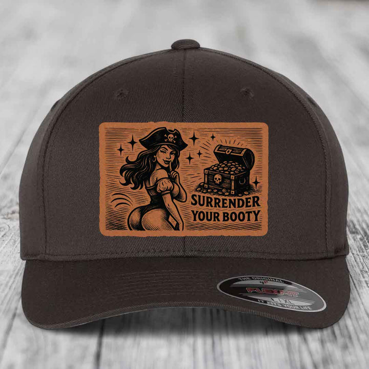 Dark brown Flexfit hat with orange leatherette patch showing pirate woman and treasure chest with text &