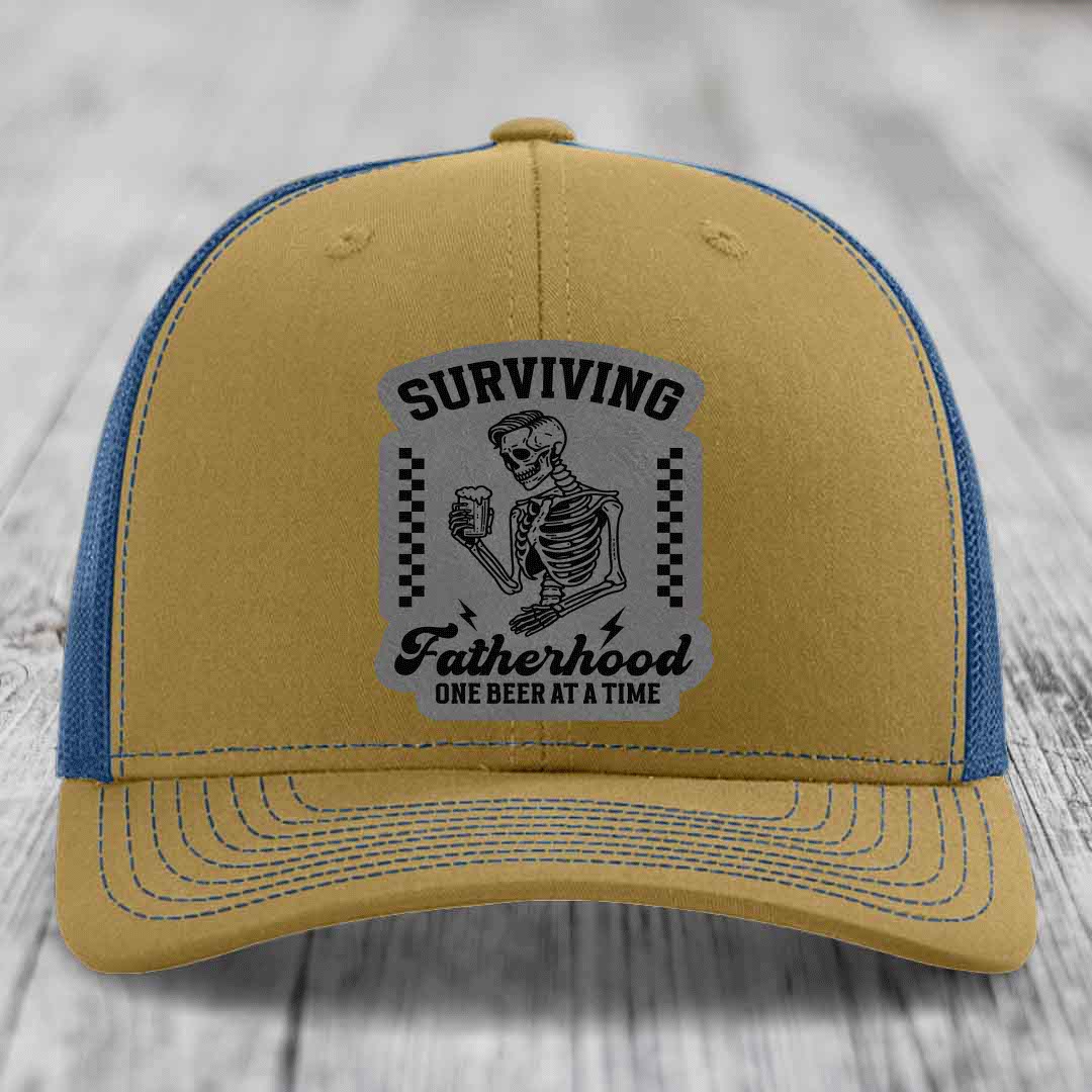 Tan trucker hat with blue mesh back and gray patch showing skeleton holding beer with text &
