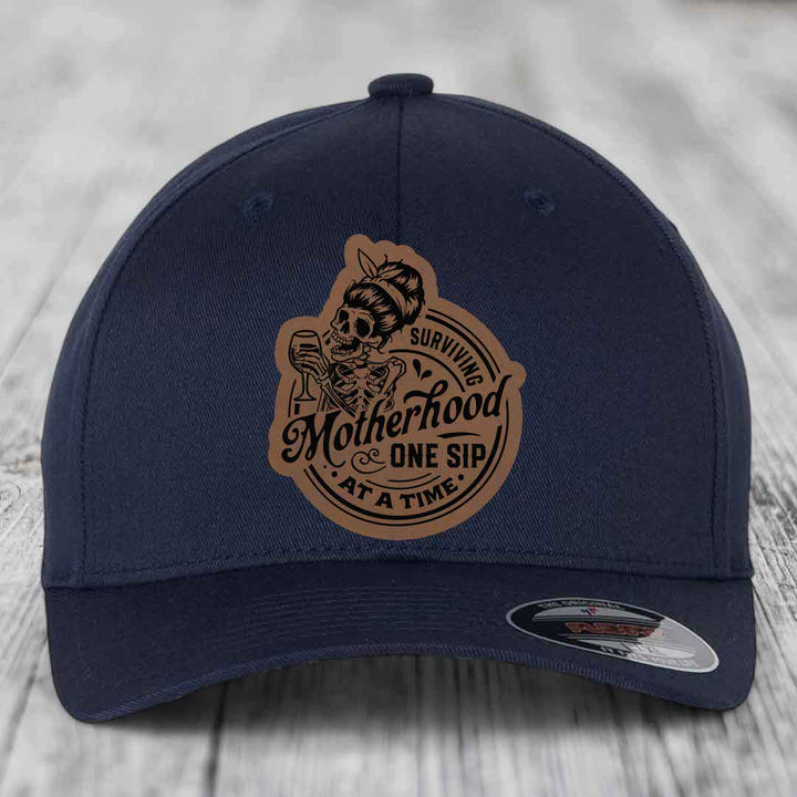 Surviving Motherhood, One Sip At A Time - Leather Patch Hat - Dark Brown to Black Patch - Flexfit 6277 Fitted Hat
