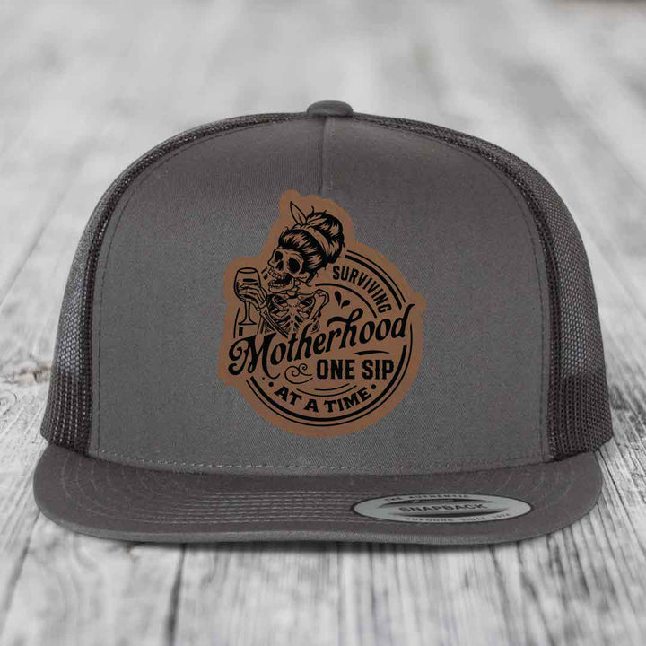 Surviving Motherhood, One Sip At A Time - Leather Patch Hat - Dark Brown to Black Patch - Yupoong 6006 Snapback Flatbill Hat