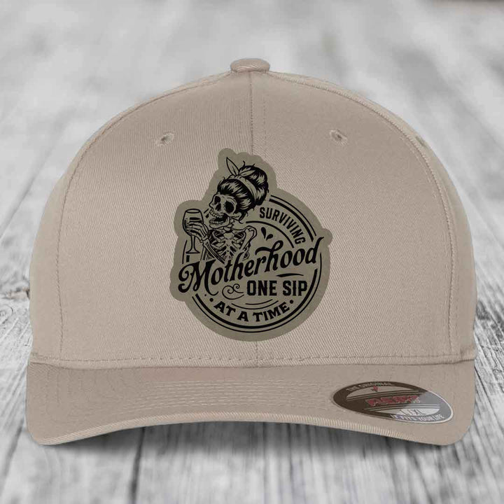 Surviving Motherhood, One Sip At A Time - Leather Patch Hat - Light Brown to Black Patch - Flexfit 6277 Fitted Hat