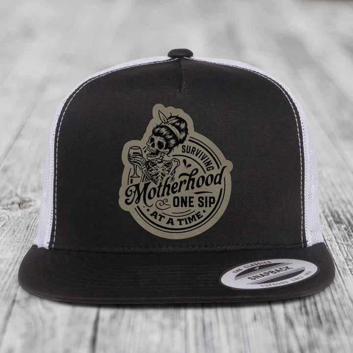 Surviving Motherhood, One Sip At A Time - Leather Patch Hat - Light Brown to Black Patch - Yupoong 6006 Snapback Flatbill Hat