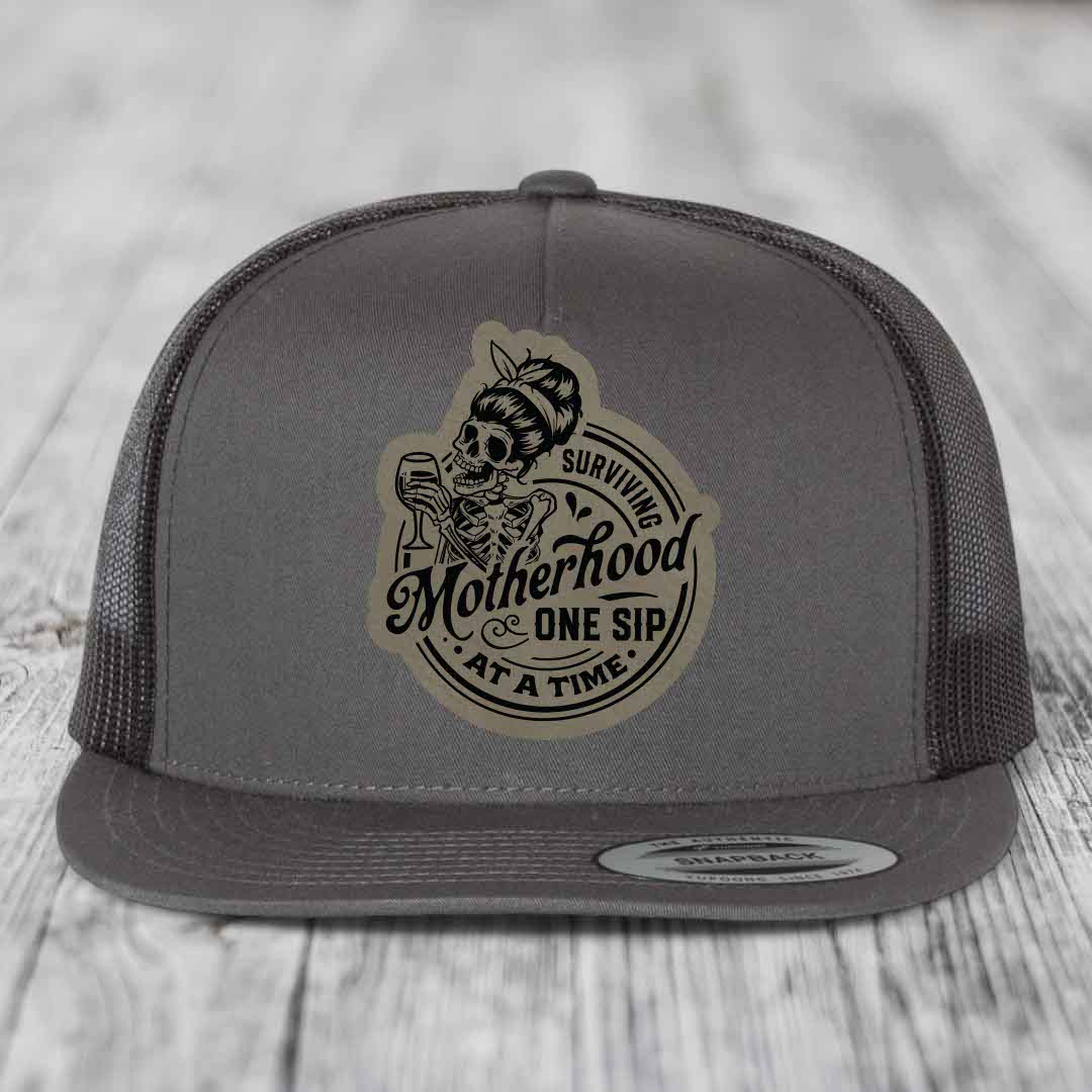 Surviving Motherhood, One Sip At A Time - Leather Patch Hat - Light Brown to Black Patch - Yupoong 6006 Snapback Flatbill Hat