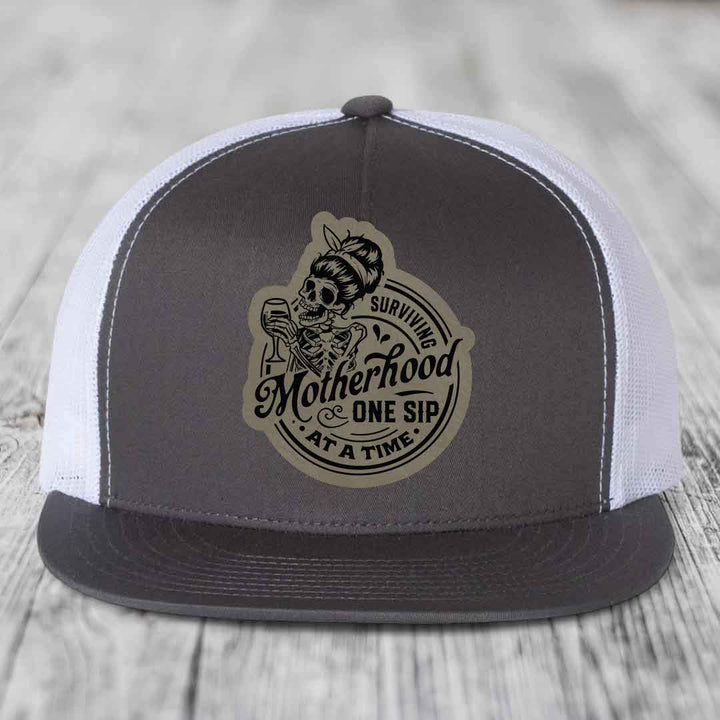 Surviving Motherhood, One Sip At A Time - Leather Patch Hat - Light Brown to Black Patch - Yupoong 6006 Snapback Flatbill Hat
