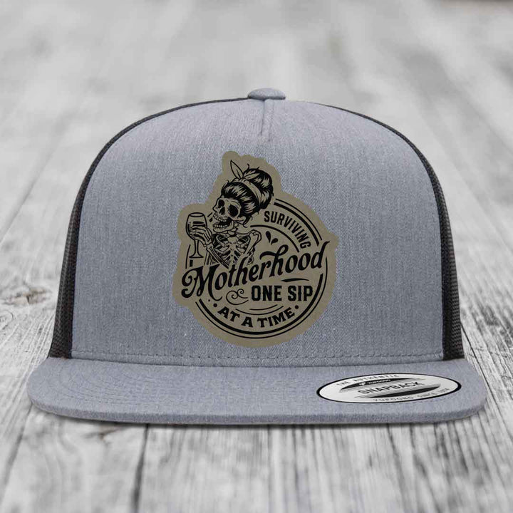 Surviving Motherhood, One Sip At A Time - Leather Patch Hat - Light Brown to Black Patch - Yupoong 6006 Snapback Flatbill Hat