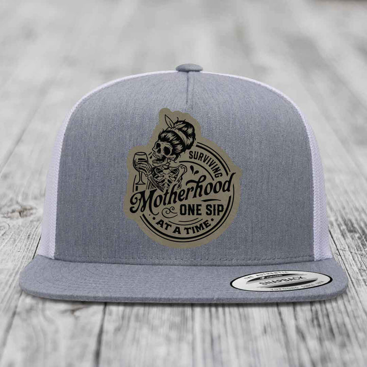 Surviving Motherhood, One Sip At A Time - Leather Patch Hat - Light Brown to Black Patch - Yupoong 6006 Snapback Flatbill Hat
