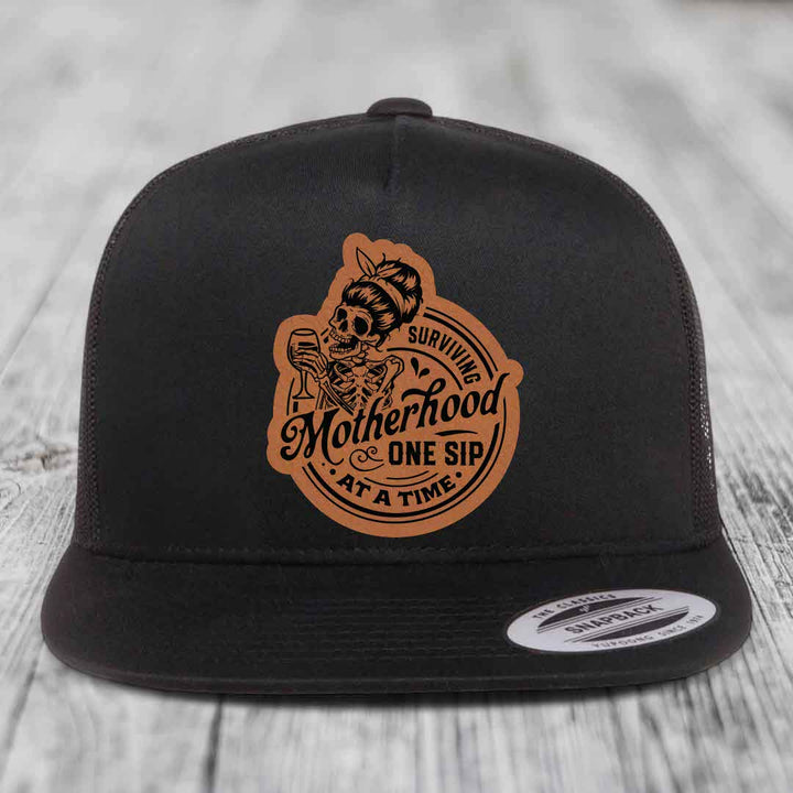 Surviving Motherhood, One Sip At A Time - Leather Patch Hat - Rawhide to Black Patch - Yupoong 6006 Snapback Flatbill Hat