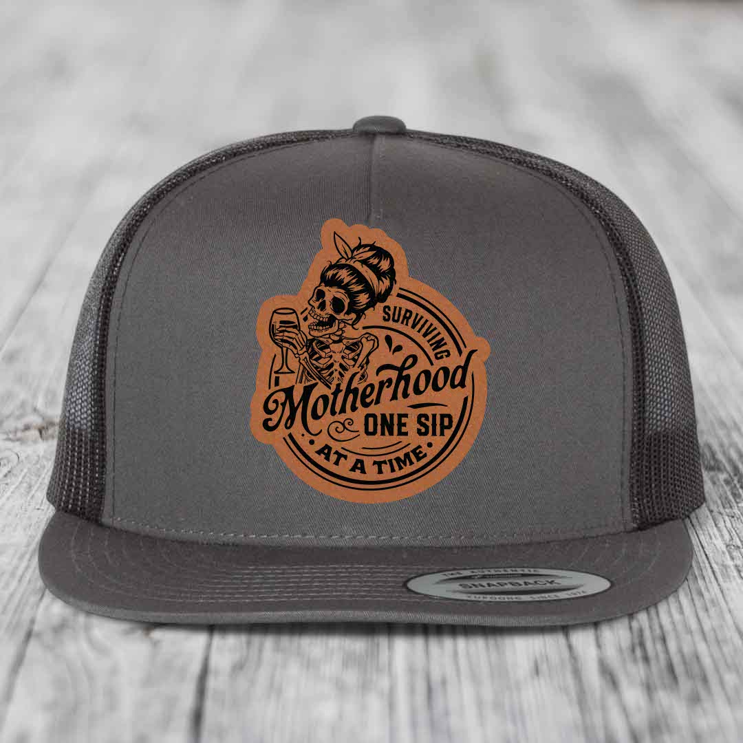 Surviving Motherhood, One Sip At A Time - Leather Patch Hat - Rawhide to Black Patch - Yupoong 6006 Snapback Flatbill Hat