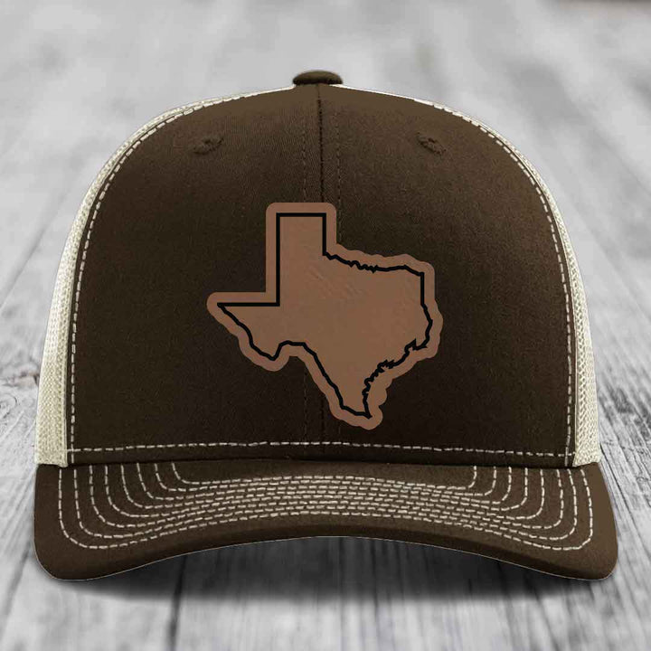 Brown trucker hat with Texas state outline patch and white stitching on front panel.