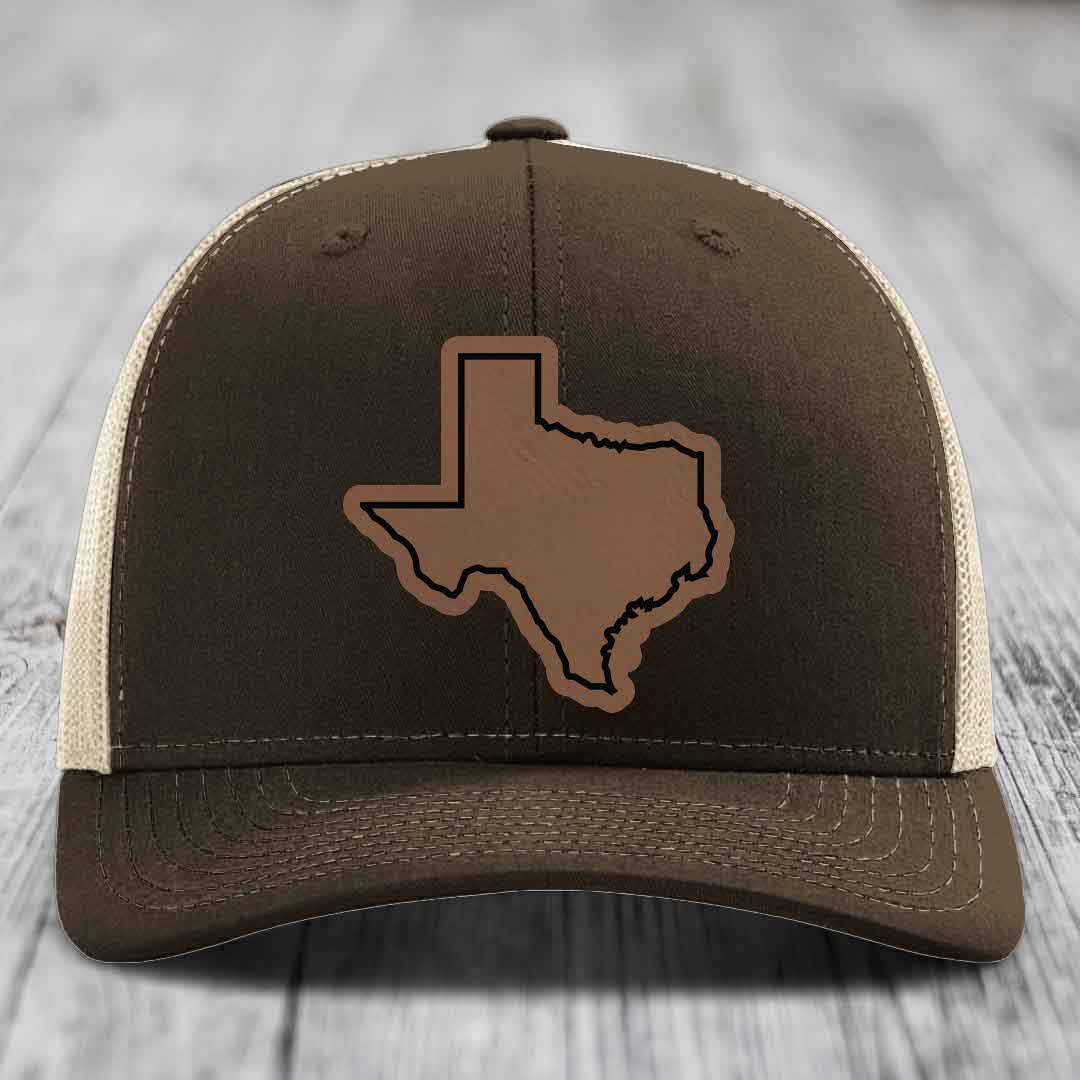 Brown trucker hat with Texas state outline patch on front, cream mesh back, stitched details.
