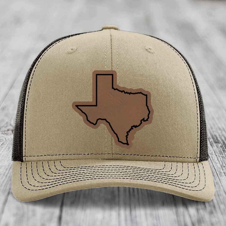 Tan trucker hat with brown Texas state outline patch on front, black mesh back.