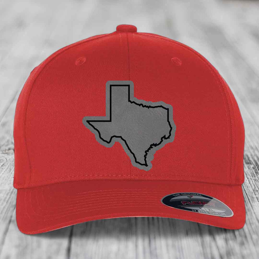 Red baseball cap with grey Texas state outline patch on front, branded Flexfit label.