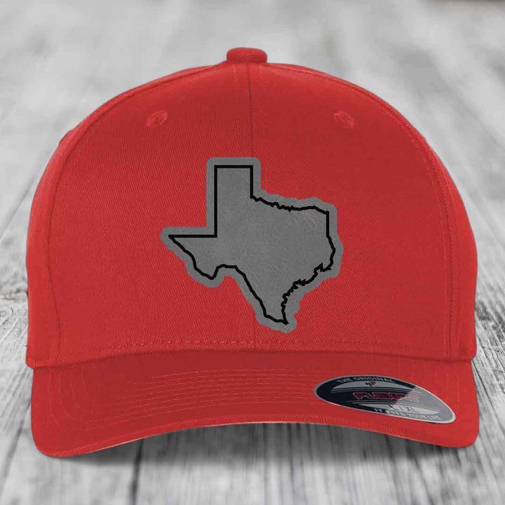 Red baseball cap with grey Texas state outline patch on front, branded Flexfit label.