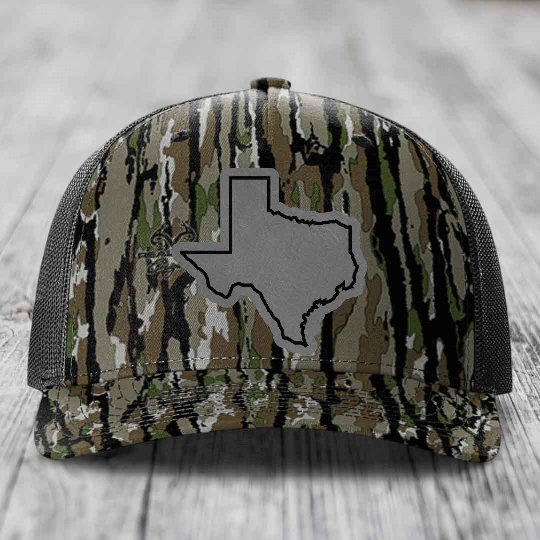 Camouflage trucker hat with gray Texas state outline patch on front.