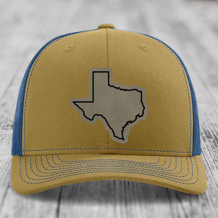 Tan and blue trucker hat with gray Texas state outline patch on front.