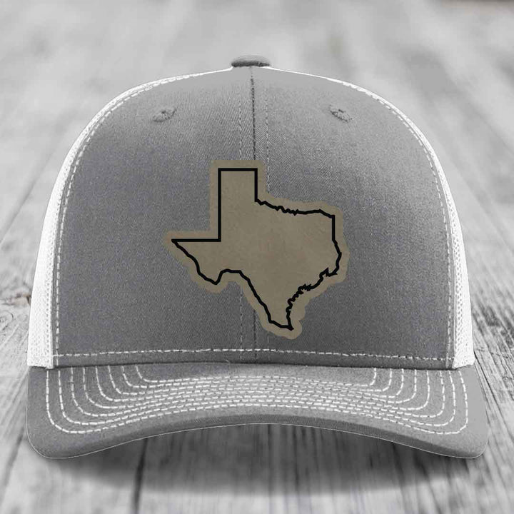 Grey trucker hat with Texas state outline patch on front, white mesh back and stitching.