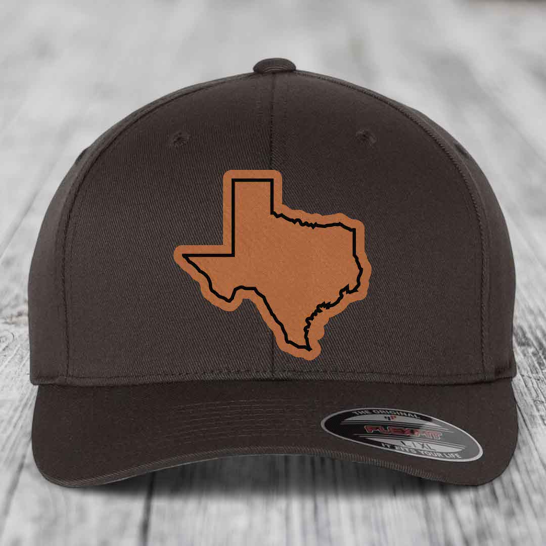 Dark brown baseball cap with tan Texas state outline patch on front, Flexfit brand label visible.