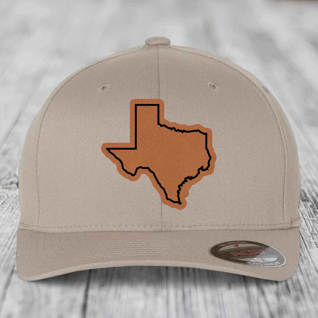 Beige baseball cap with brown leatherette Texas state outline patch on front.