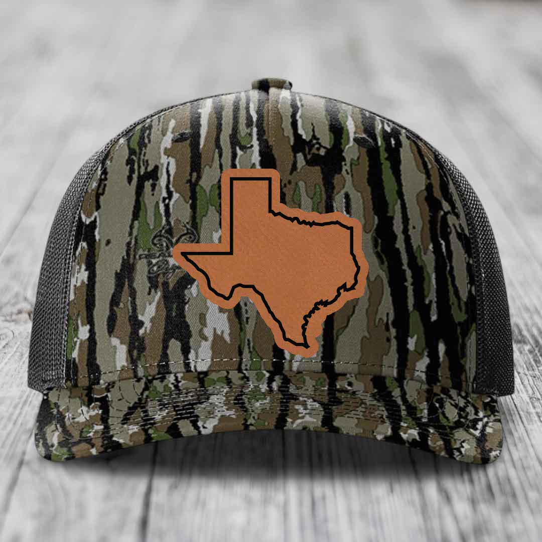 Camouflage trucker hat with brown leather Texas state patch on front.