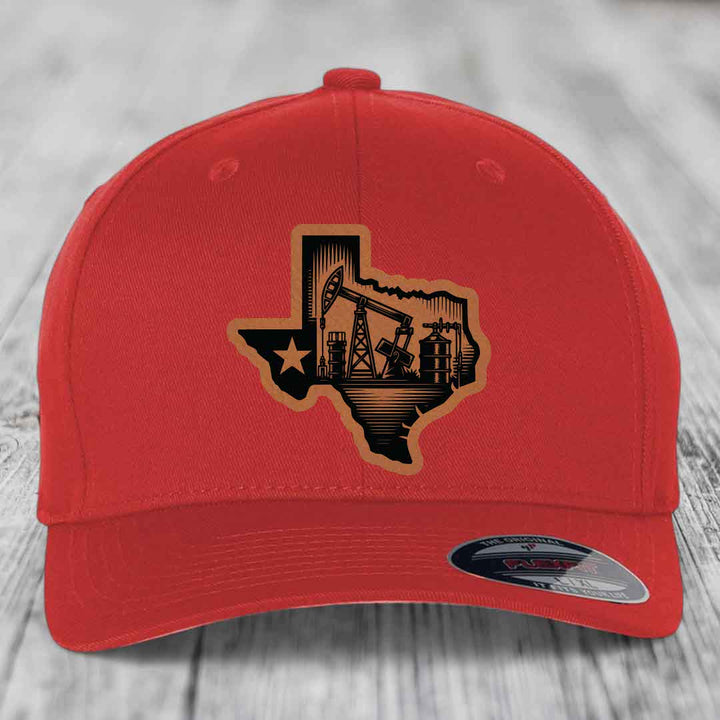 Red baseball cap with Texas oilfield patch featuring pumpjacks and star.