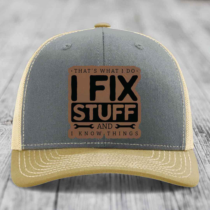 Grey and beige trucker hat with brown leather patch reading &