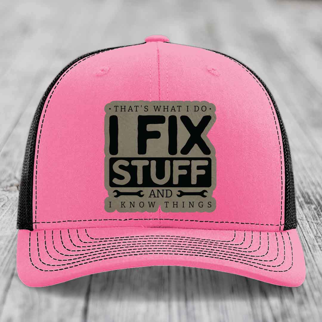 Pink trucker hat with black mesh back and gray leatherette patch reading &