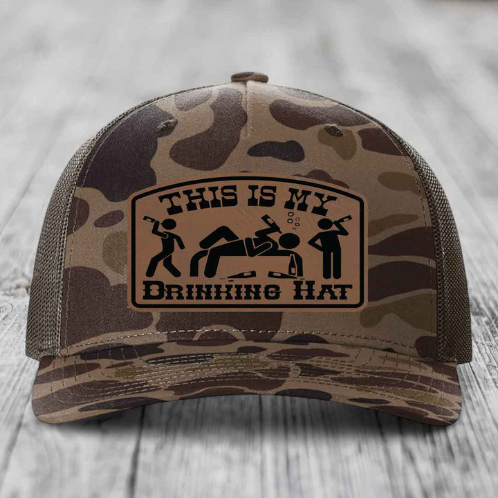 Camouflage trucker hat with brown leather patch reading &