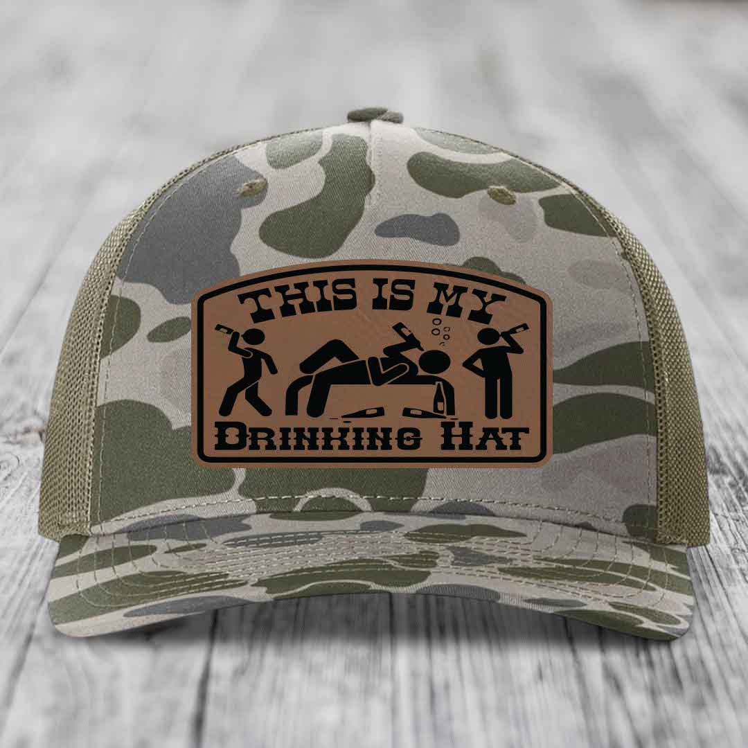 Camouflage trucker hat with brown leather patch reading &