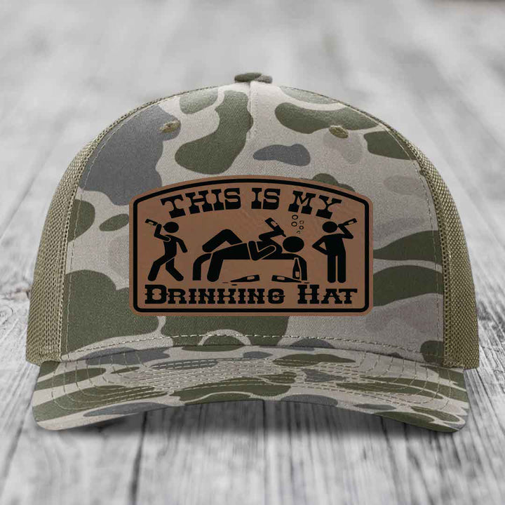 Camouflage trucker hat with brown leather patch reading &
