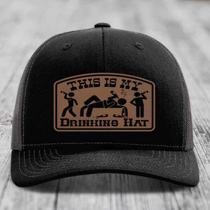 Black trucker hat with brown leather patch reading &
