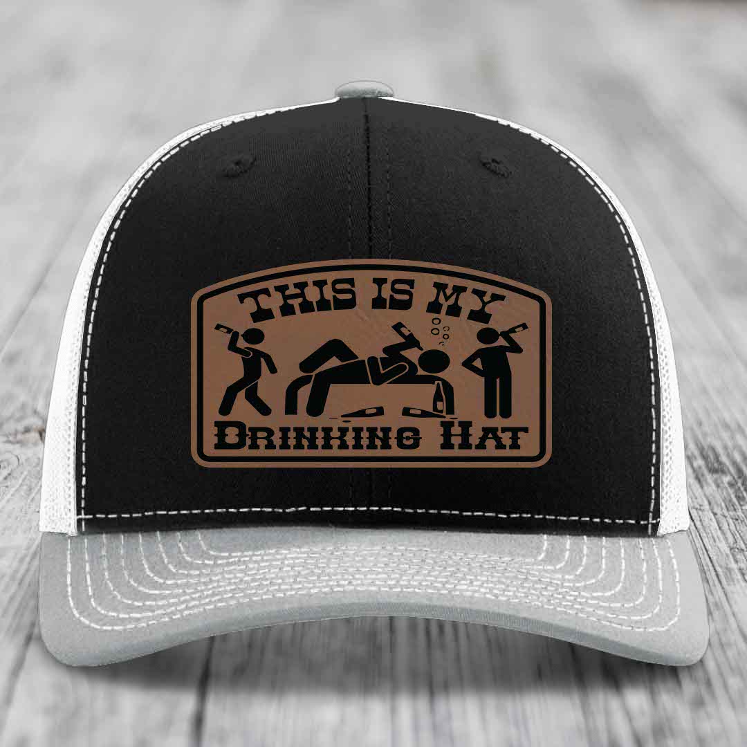 Black trucker hat with brown leather patch reading &