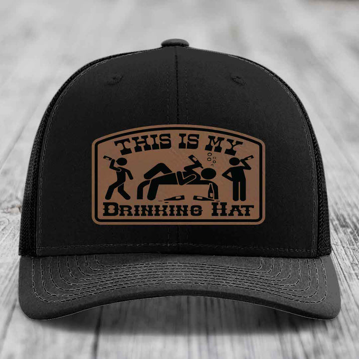 Black trucker hat with brown leather patch reading &