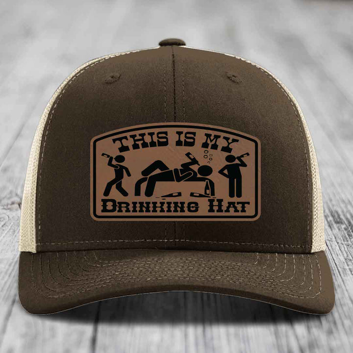 Brown trucker hat with tan mesh back and a leather patch that reads &
