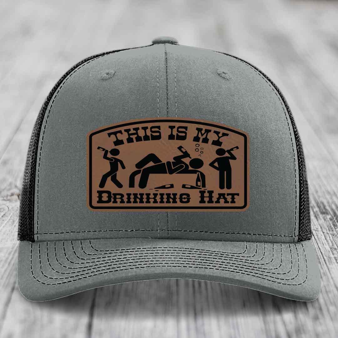 Grey trucker hat with brown leather patch reading &