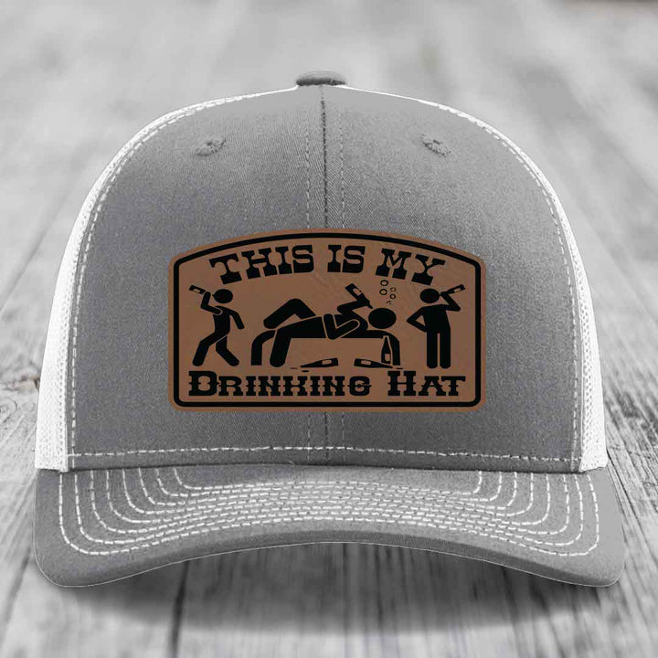 Grey trucker hat with brown leather patch reading &