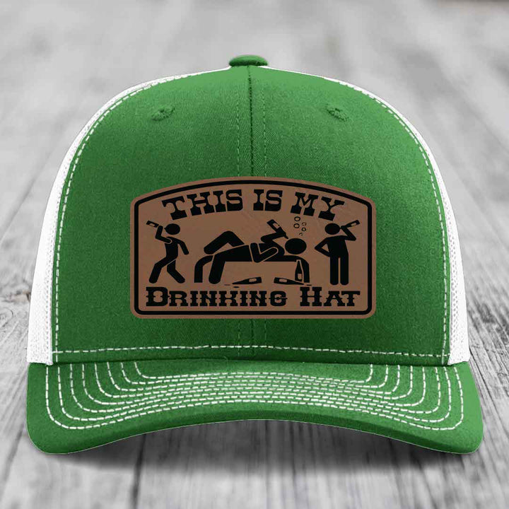 Green trucker hat with white mesh back and stitching, featuring a brown leatherette patch that reads &