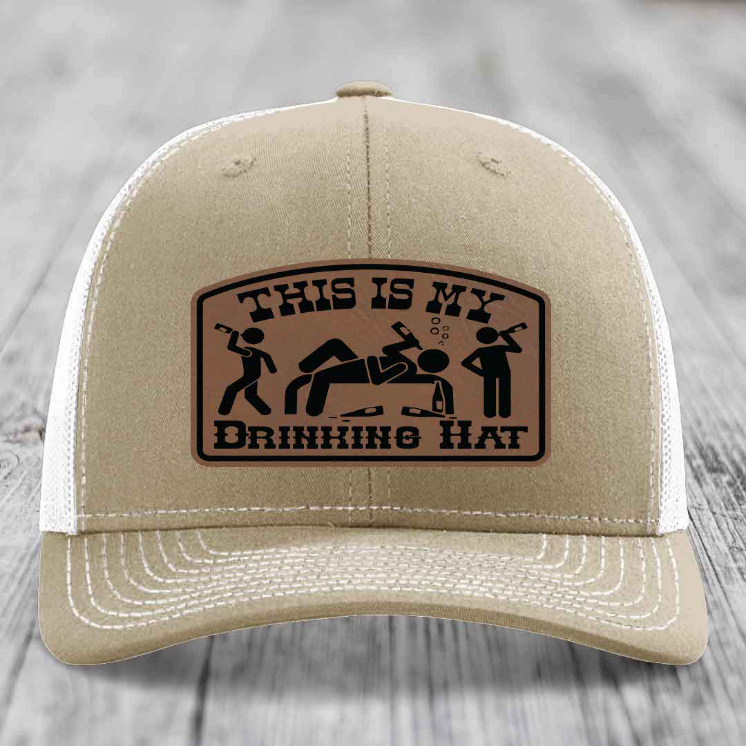 Tan trucker hat with brown leather patch reading &