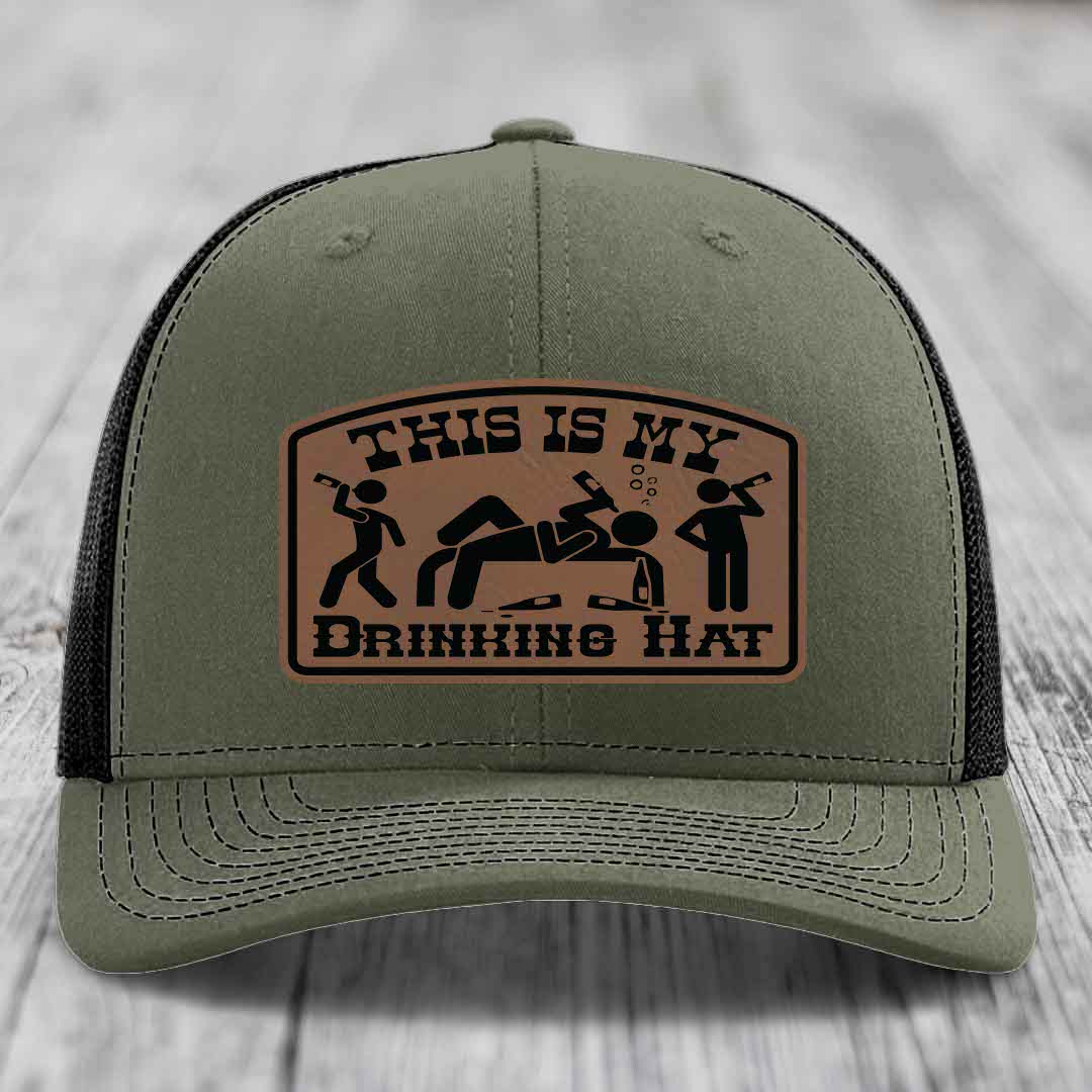 Olive green trucker hat with brown leather patch reading &