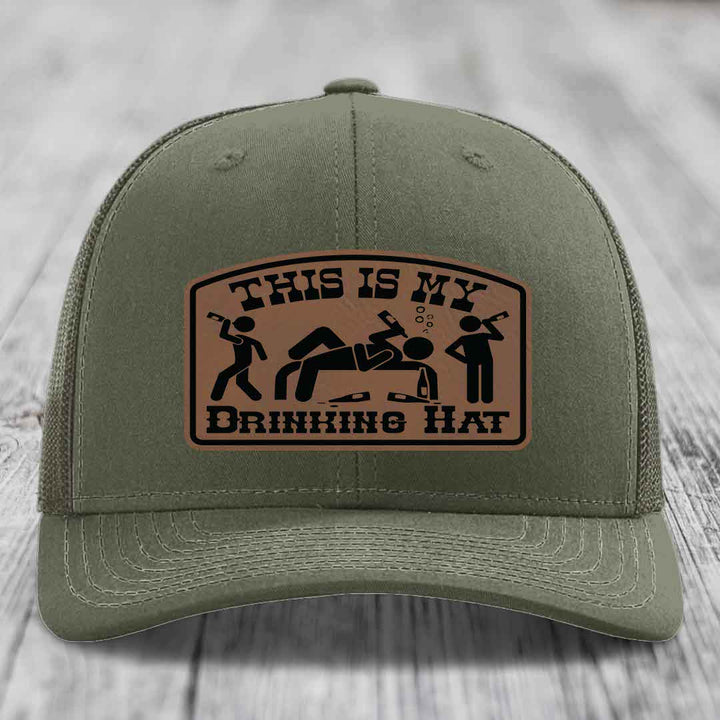 Olive green trucker hat with brown leather patch reading &