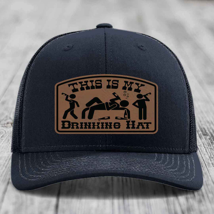 Black trucker hat with brown leather patch reading &