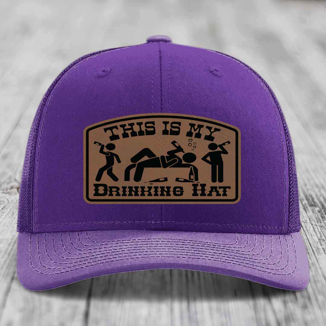 Purple trucker hat with brown leather patch reading &