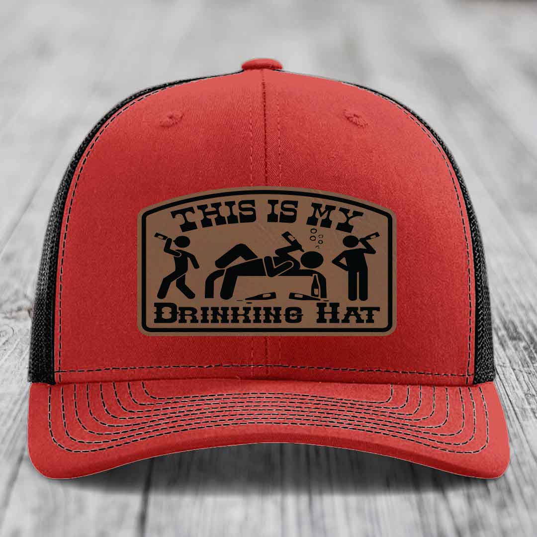 Red trucker hat with black mesh back and a tan leatherette patch that reads &