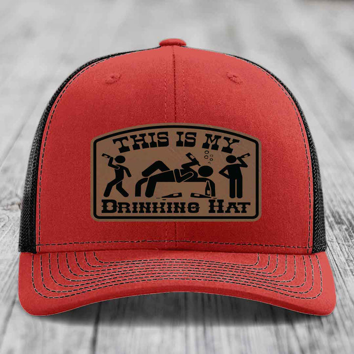 Red trucker hat with black mesh back and a tan leatherette patch that reads &