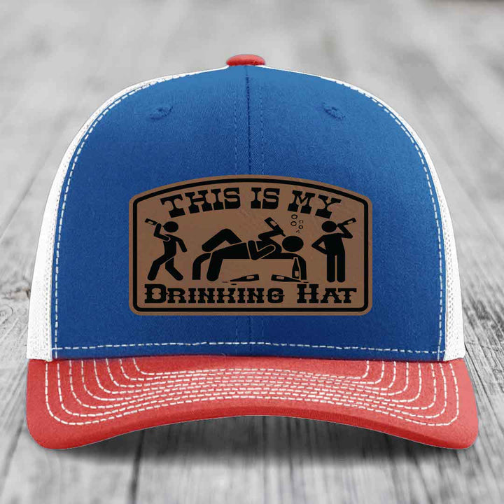 Blue and red trucker hat with a brown leather patch that says &